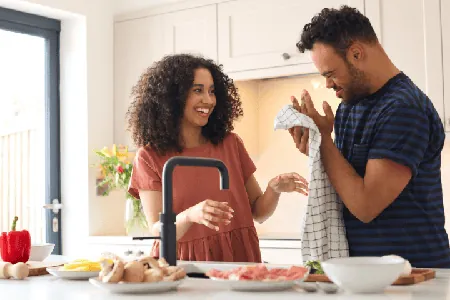 A support worker and a participant preparing a meal together in a kitchen